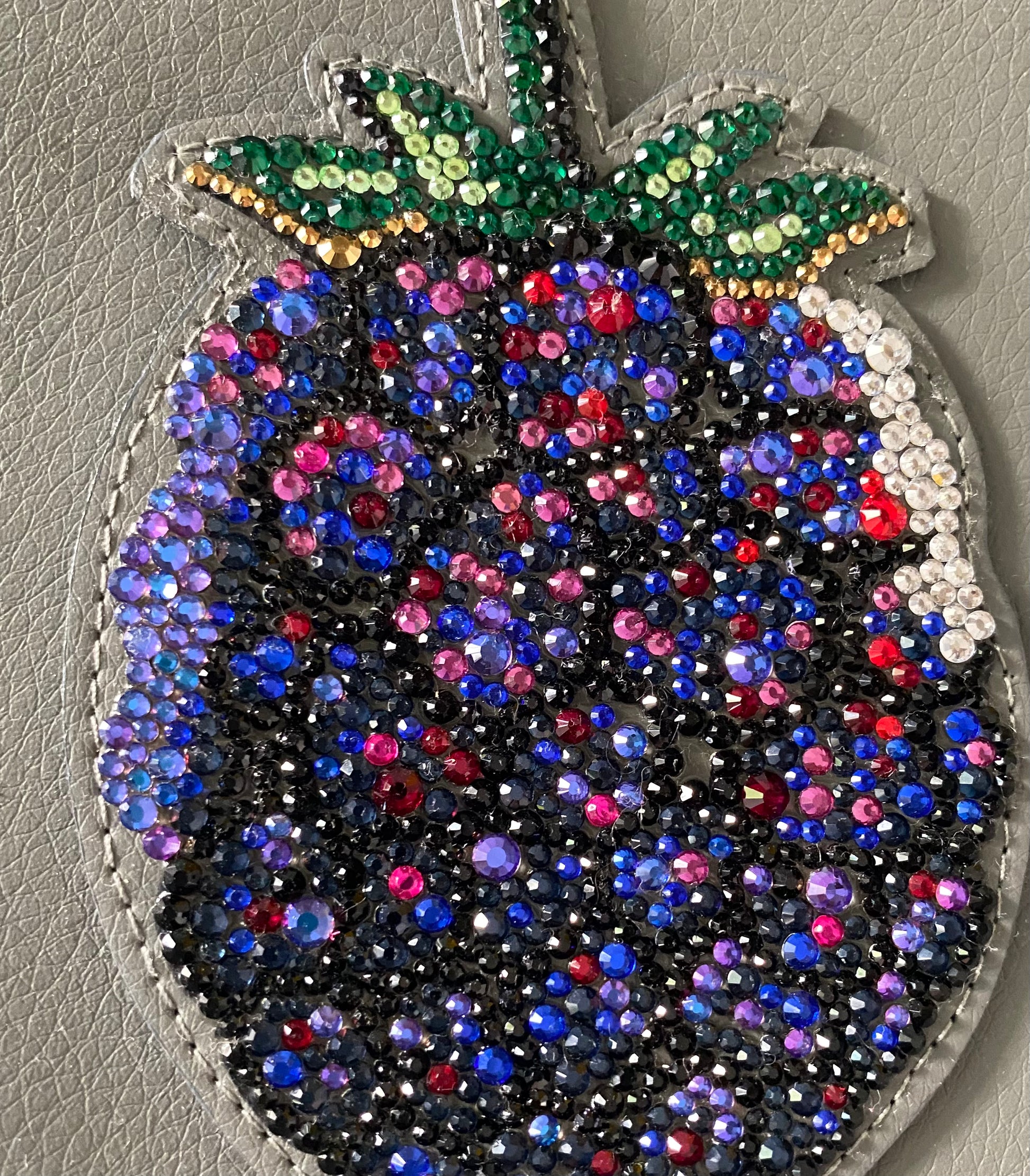 Detailaufnahme der Glas-Strasssteine der Blackberry Clutch in Navyblau, Fuchsia und Schwarz

