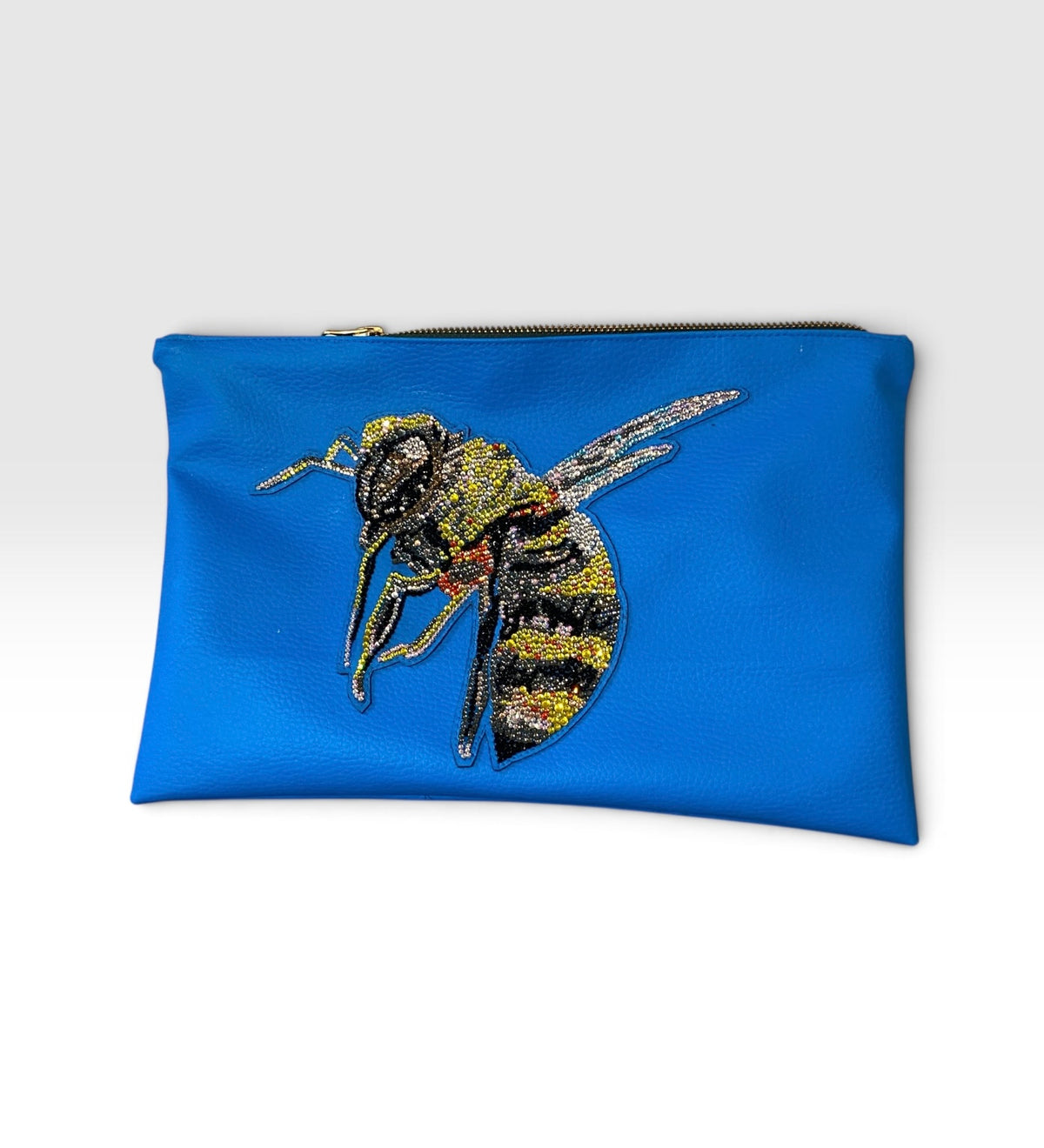 Frontansicht der Bee Clutch aus cobaltblauem veganem Leder mit handgesetzter Bienen-Applikation
