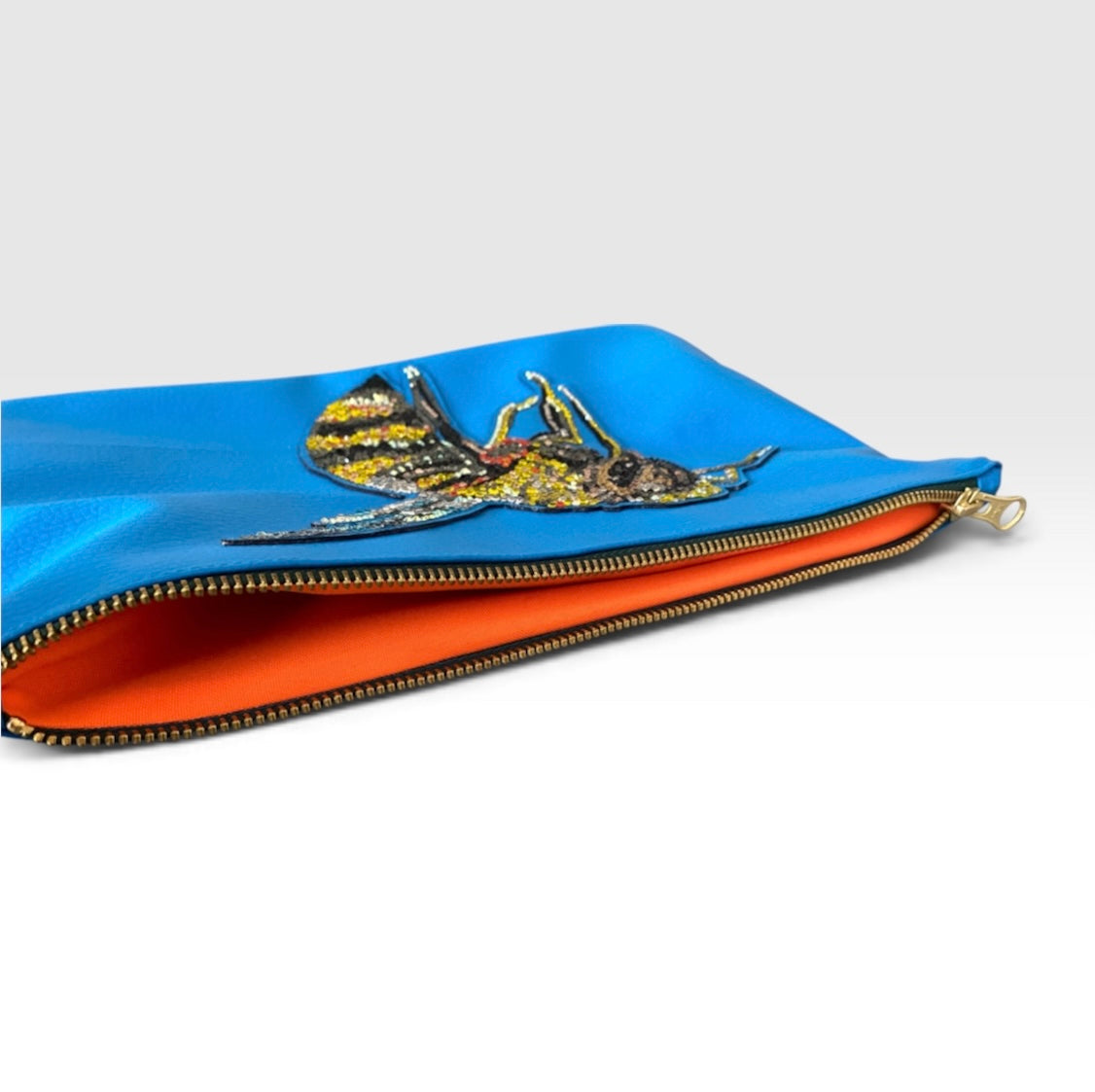 Innenansicht der Bee Clutch mit neonorangefarbenem Polyesterfutter, Forest-Green-Reißverschluss und einem Einzelfach

